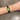 Elegant women's gold-tone watch with green dial and matching bracelet featuring green diamond-shaped charms – worn on wrist.